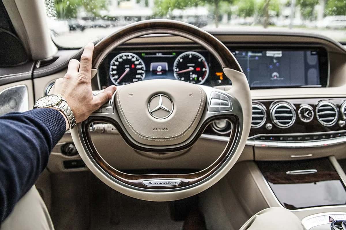 Les mains d’un chauffeur sur le volant d’une berline